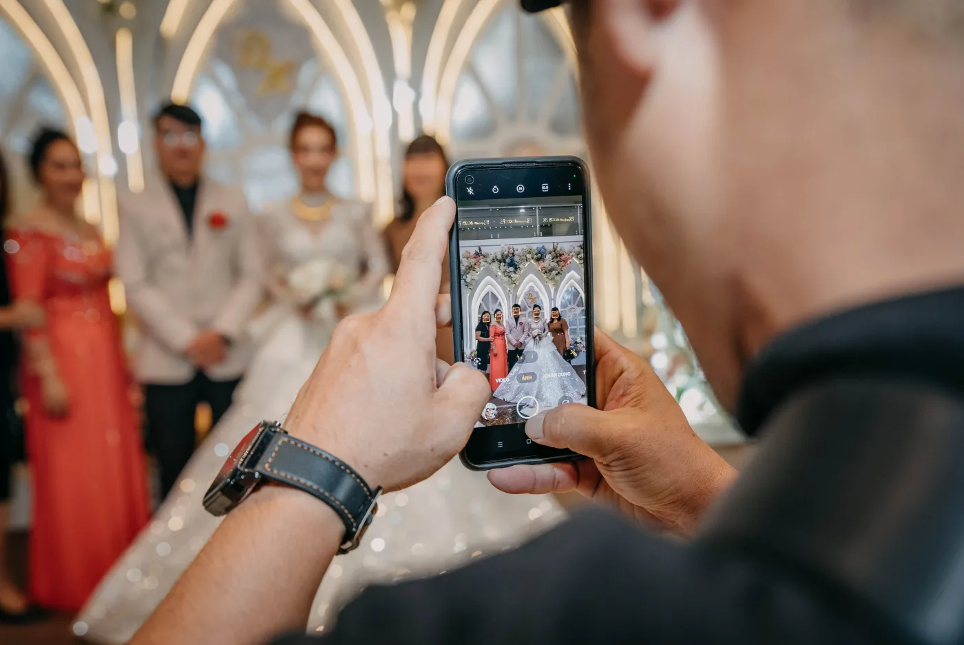 A wedding guest photographing the couple on a phone