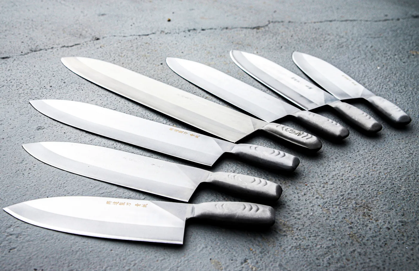 A selection of kitchen knives arranged on a work surface